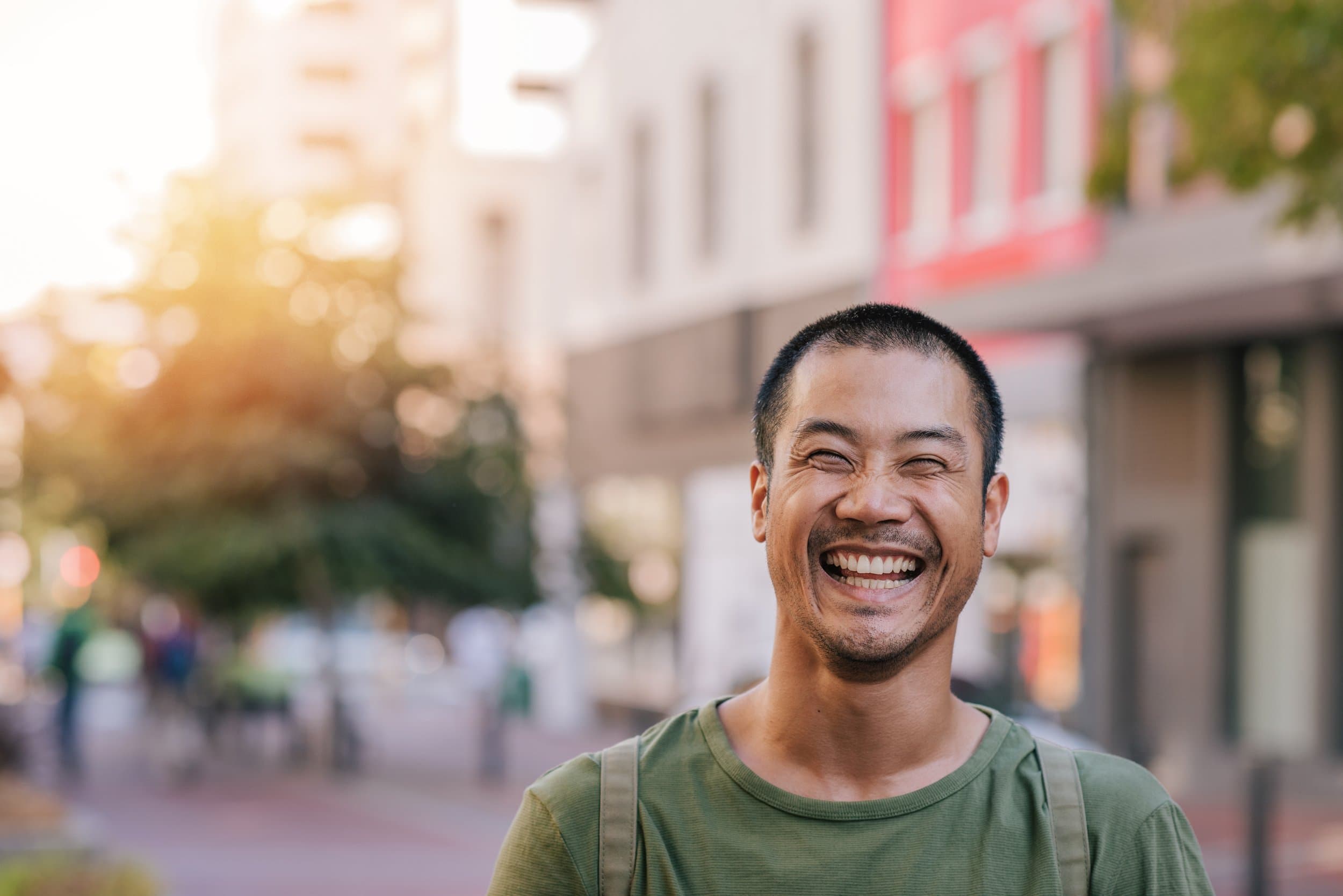 A short-haired man grinning widely.
